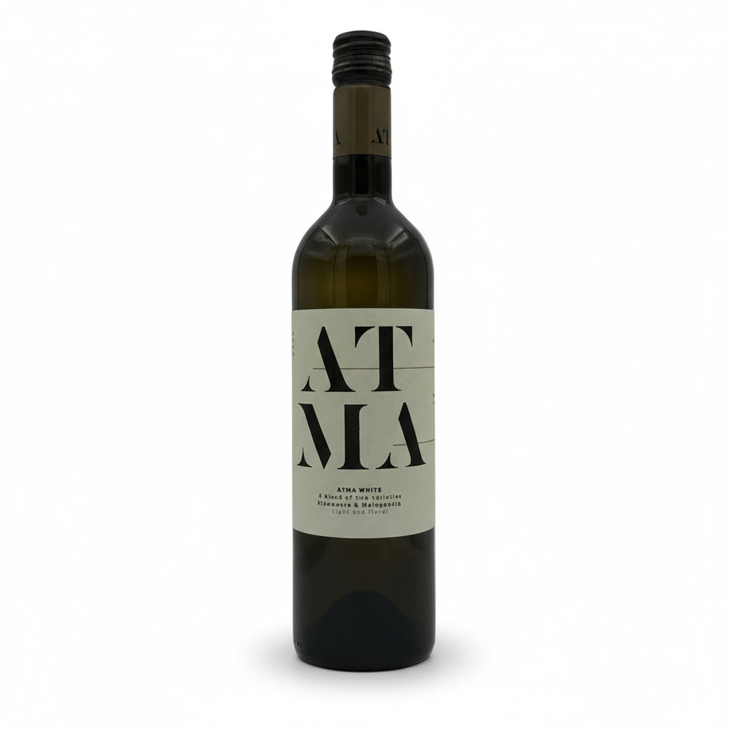 Weißwein Thymiopoulos Vineyards Atma 2023 in einem Weinglas, hellgelbe Farbe, elegante Weinflasche im Hintergrund.